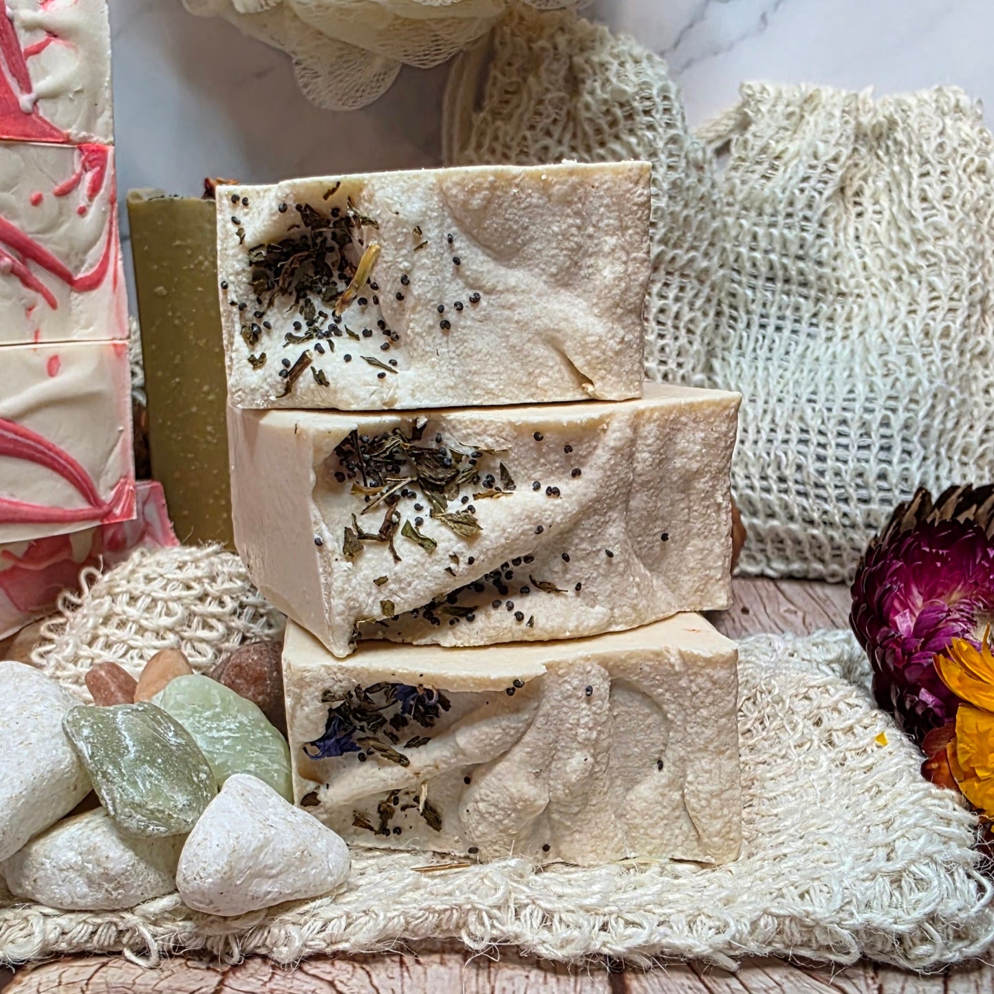 natural soap bars with herbs on a textured surface