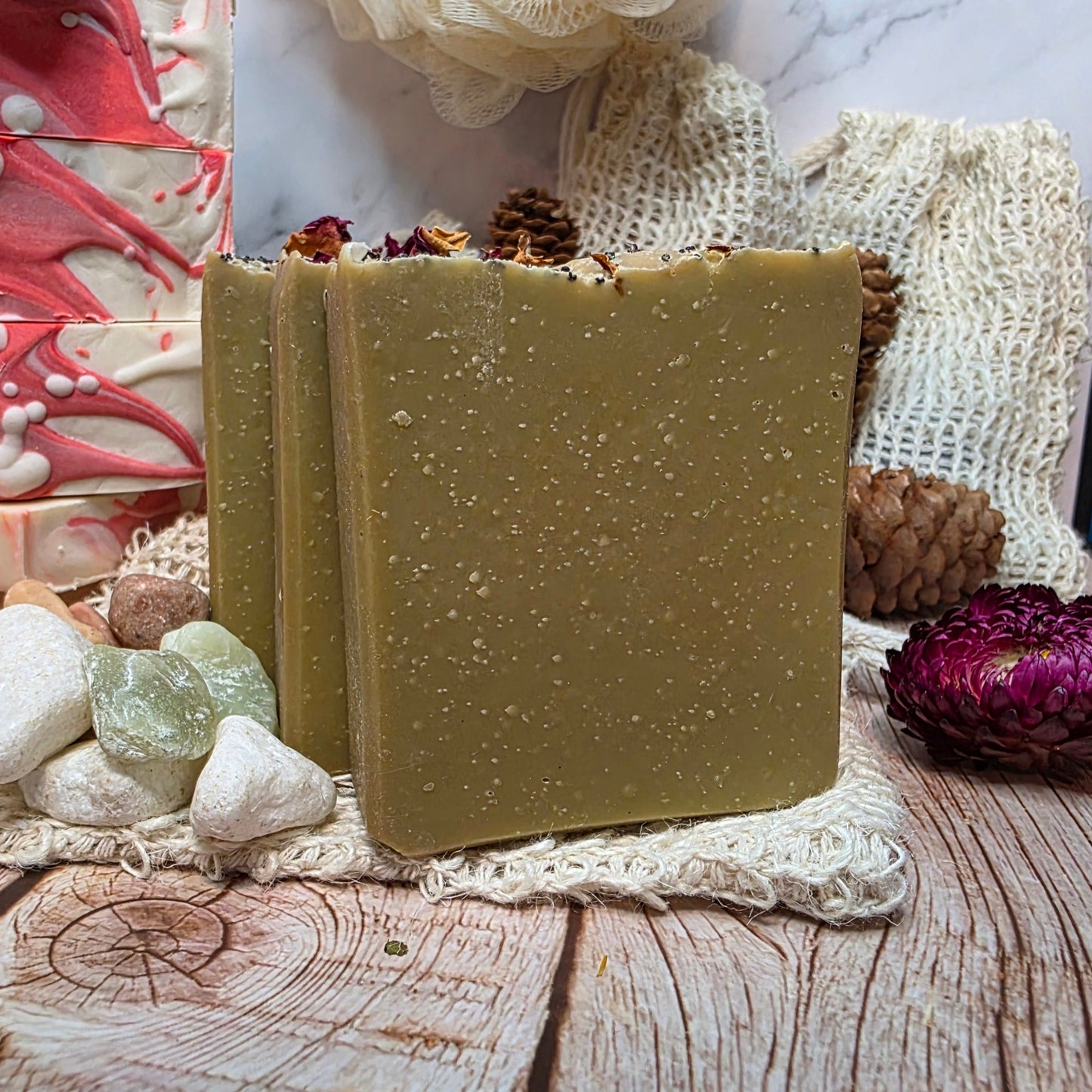 Three green soap bars on a wooden surface with decorative elements.