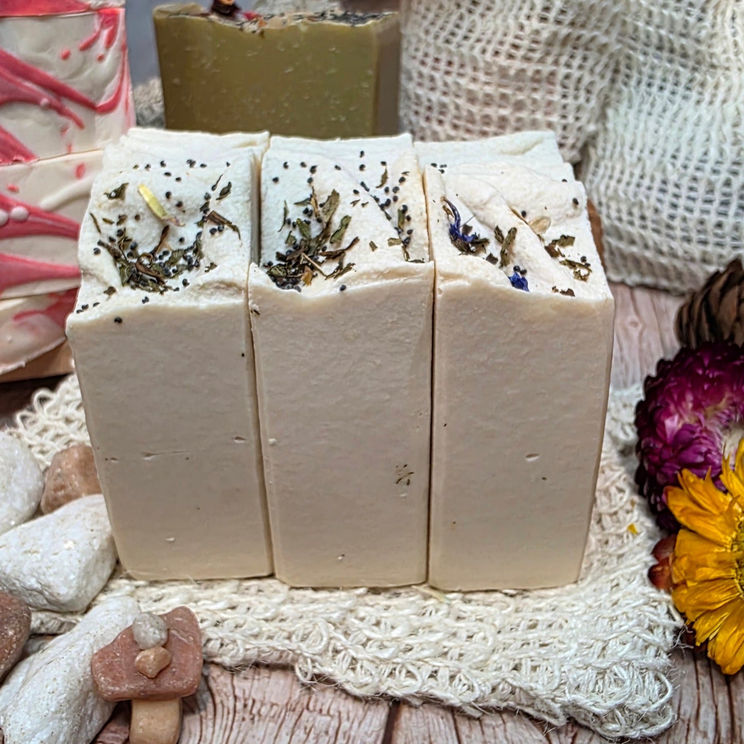 soap bars with dried herbs on a textured surface with decorative elements.