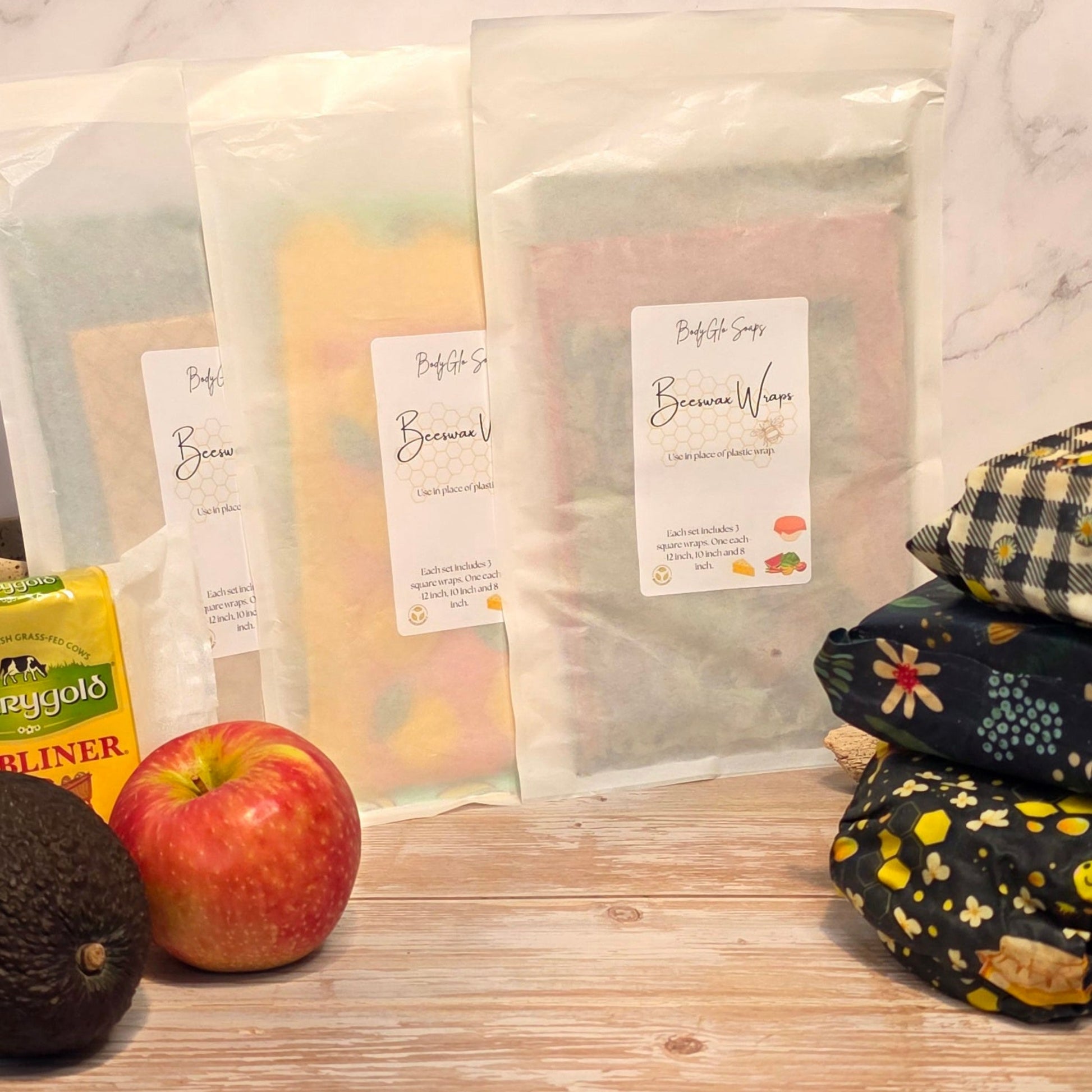 beeswax wraps and an apple on a wooden surface with a marble background