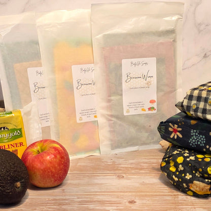 beeswax wraps and an apple on a wooden surface with a marble background