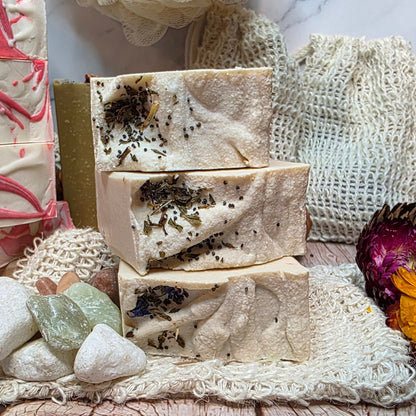 natural soap bars with herbs on a textured surface