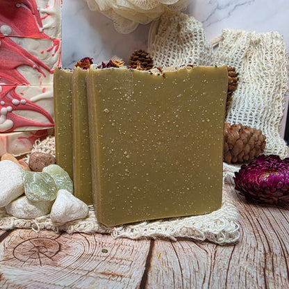 Three green soap bars on a wooden surface with decorative elements.